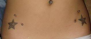 Tatuaje de 2 piercing en cruz en el pezon